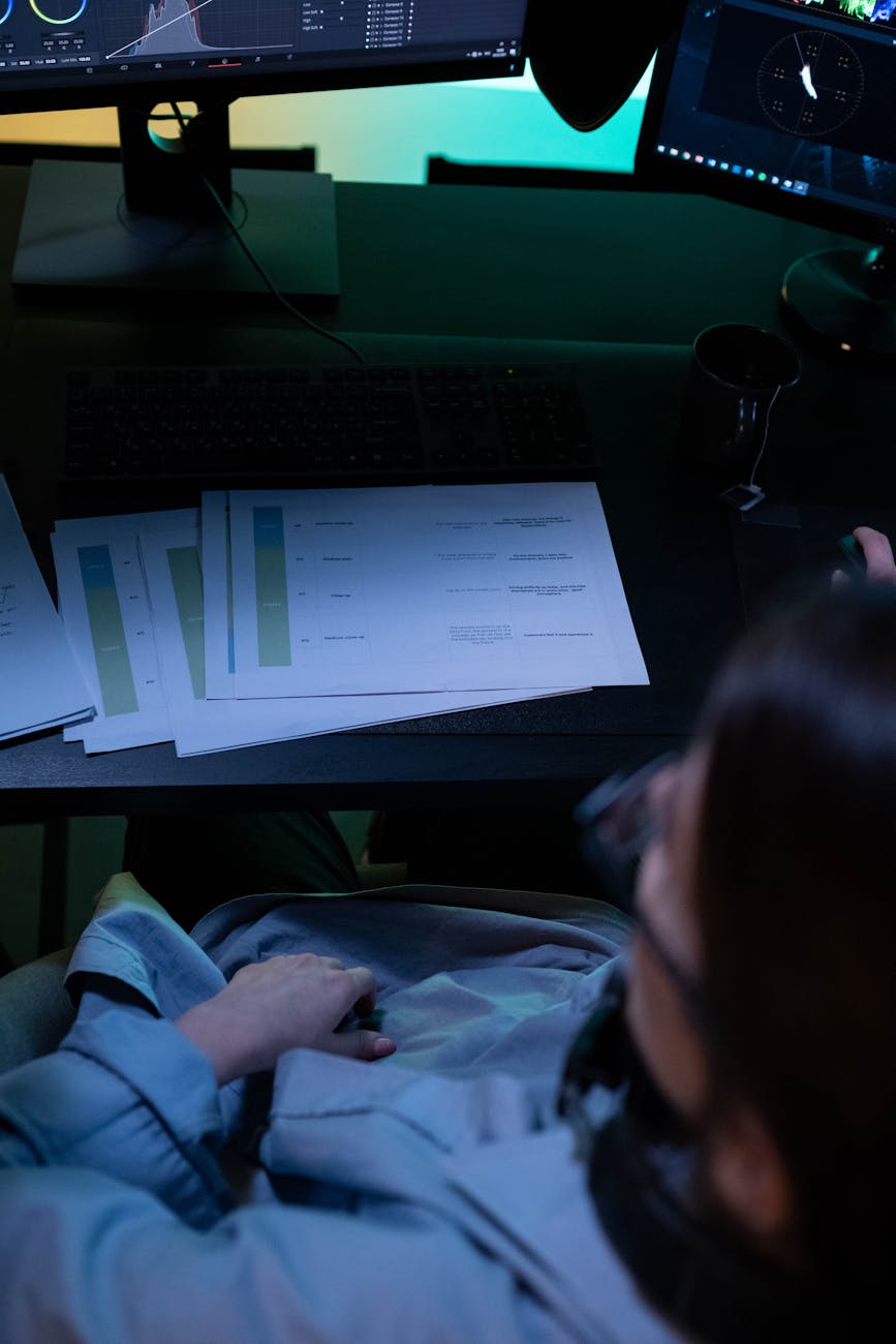 Accountant reviewing financial reports on dual monitors at clean desk