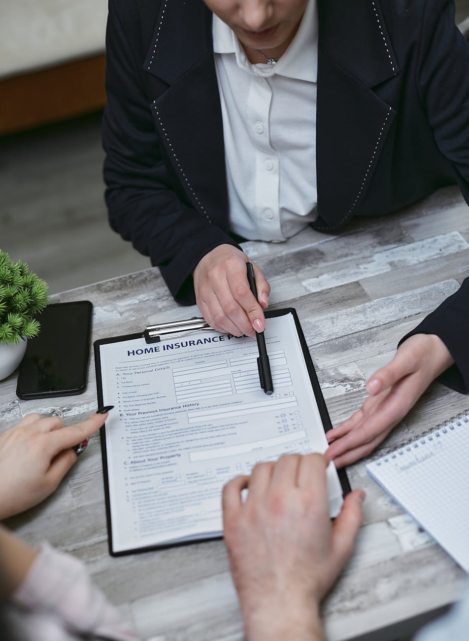 Insurance agent reviewing policy documents with client across desk