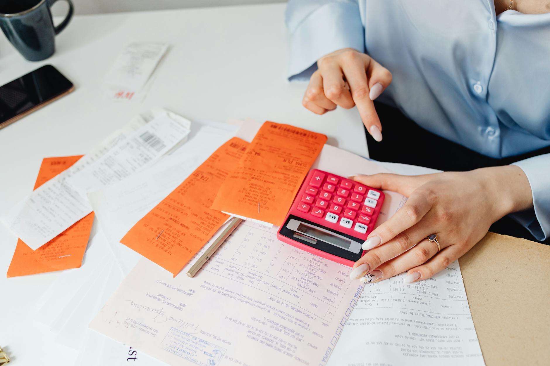 Bookkeeper working with financial spreadsheets and calculator at organized desk