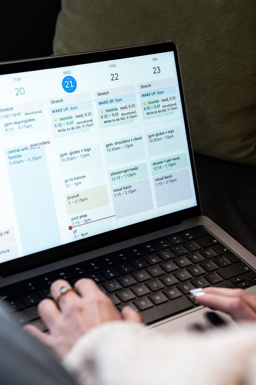 Professional woman managing calendar on laptop in bright home office